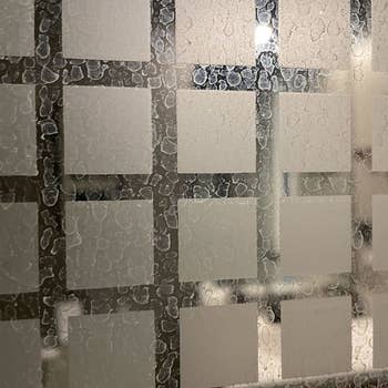 a reviewer photo of a glass shower door covered in hard water stains