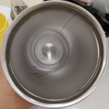 a reviewer photo of the same tumbler cup with the inside now shiny and clean