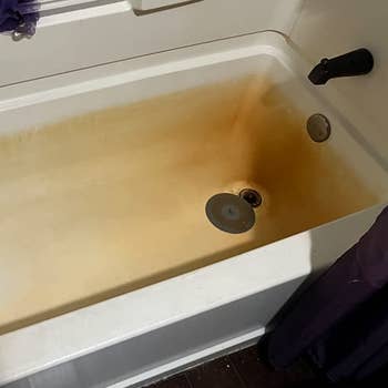 a reviewer photo of a bath tub covered in rust stains