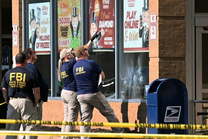 Investigators stand outside the grocery store