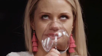 A woman rolling her eyes as she takes a sip of wine.