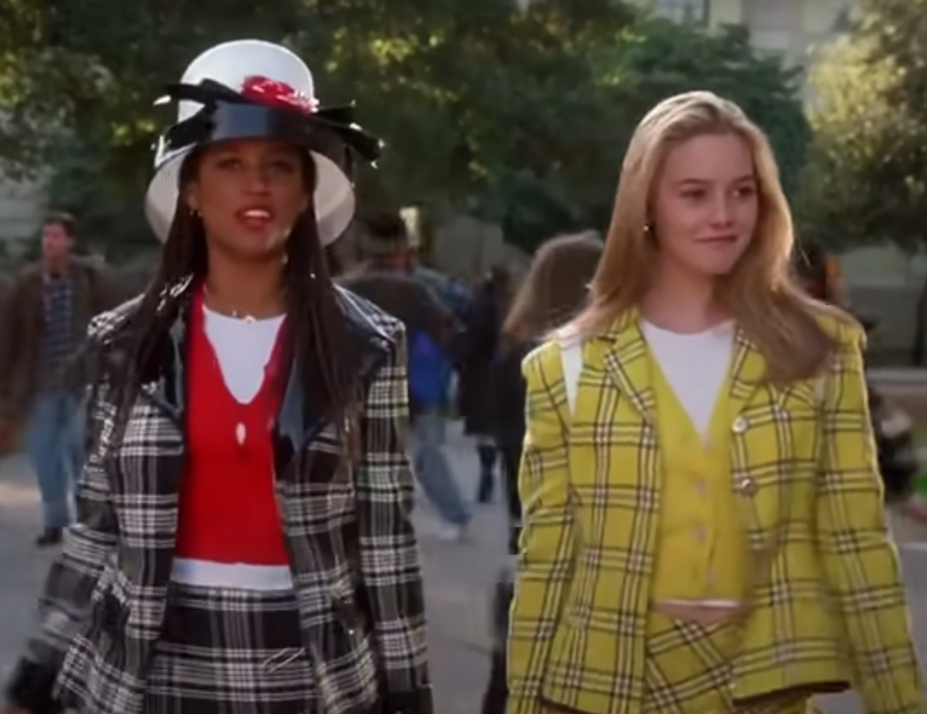 Dionne and Cher strut outside of their school in plaid co-ord outfits