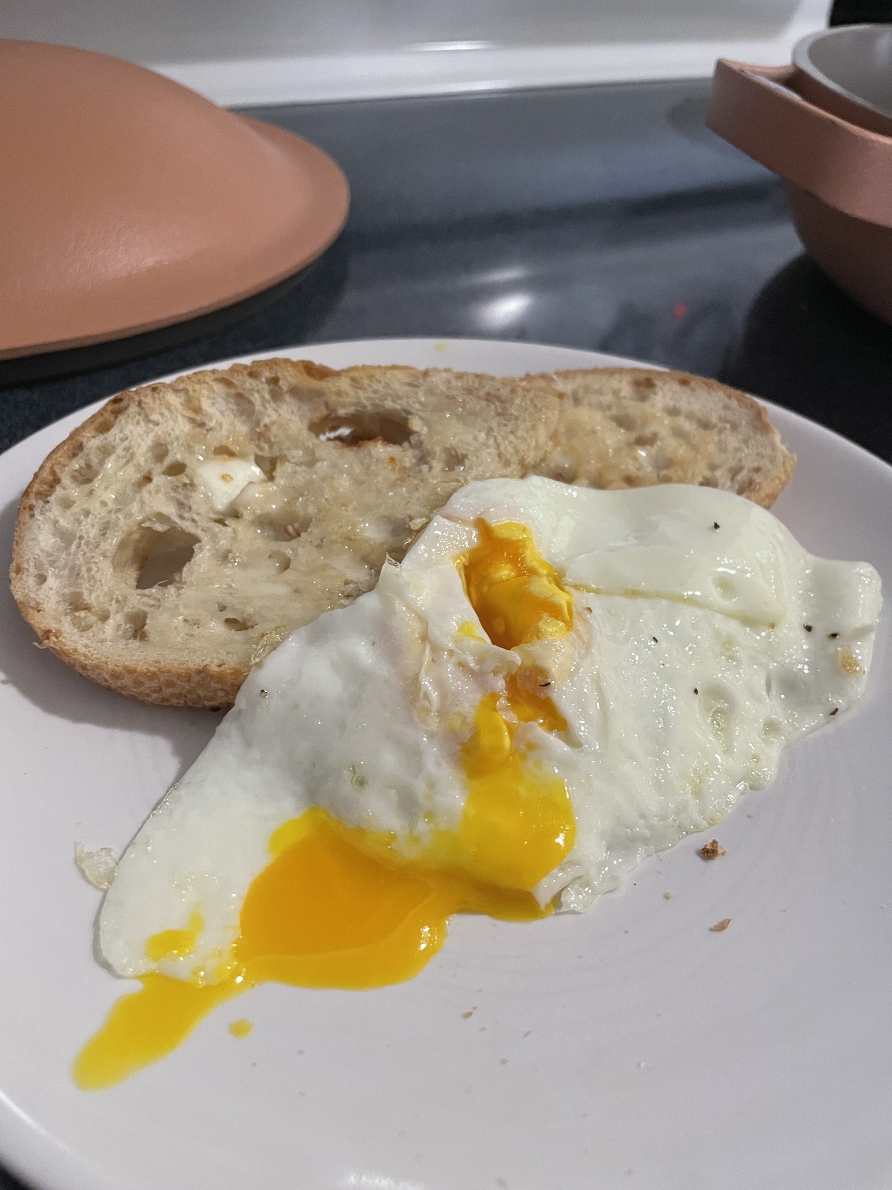 Runny over-easy egg on a plate with bread