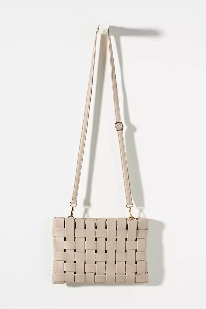 The clutch in the color Beige, with attached cross-body strap