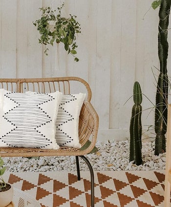 the pillow covers on two pillows, which are on a wicker patio seat