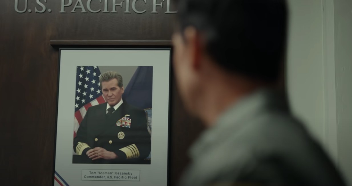 Tom Cruise looking at a framed photo of Val Kilmer in Top Gun: Maverick movie