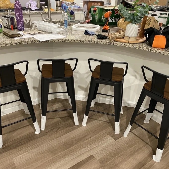 four metal bar stools with wooden top at a kitchen counter