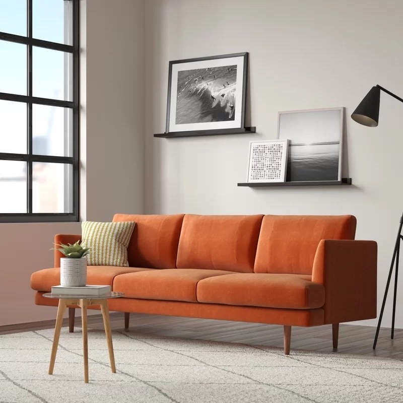 orange modern couch with straight wooden legs