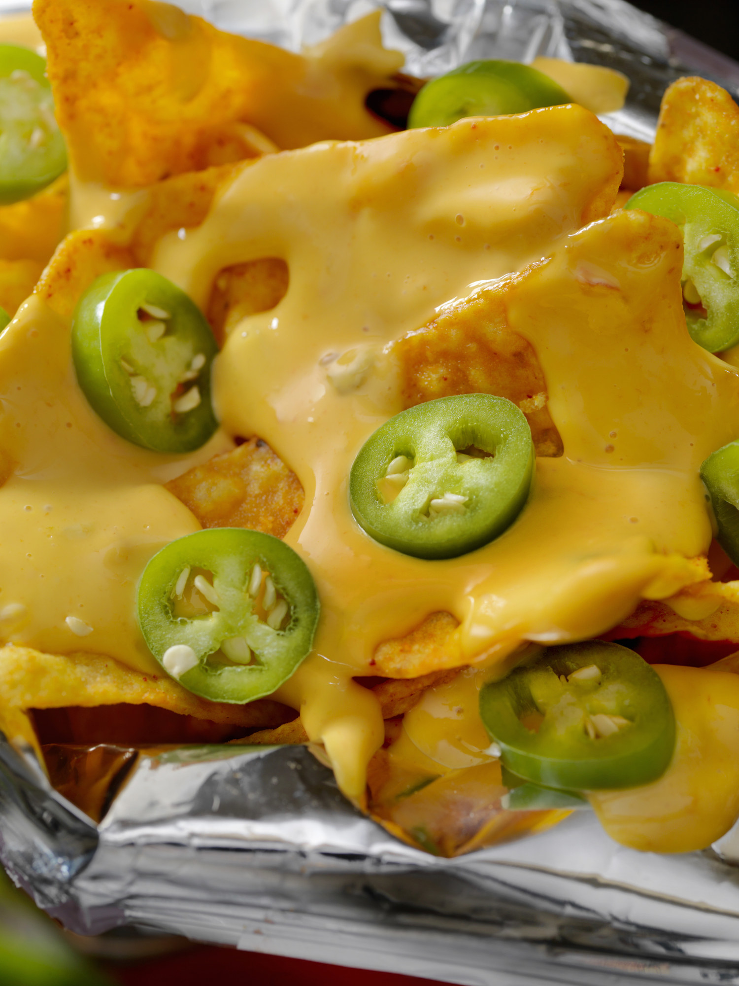 Tortilla chips with cheese sauce and jalapeños