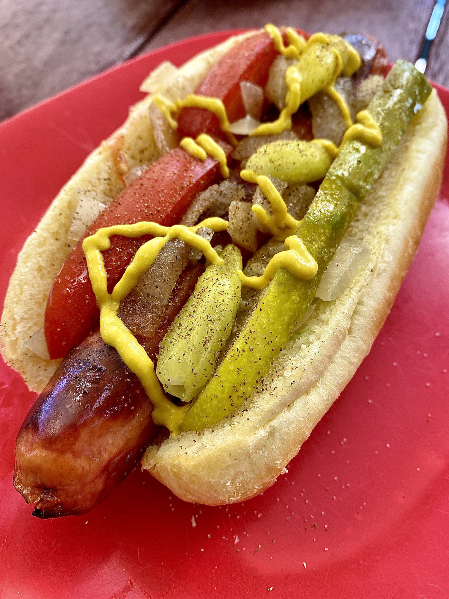 A Chicago hot dog with pickle and tomato
