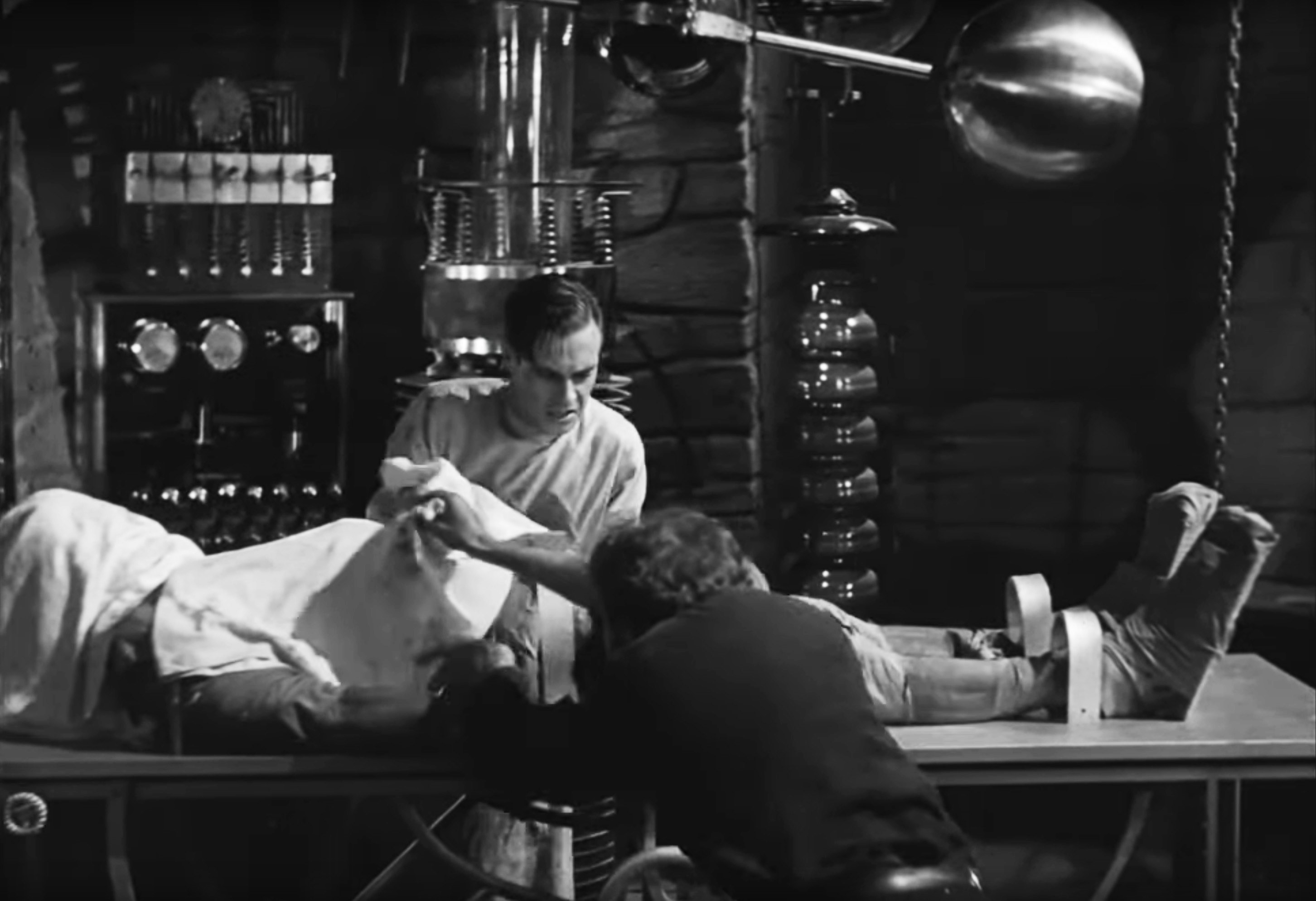 Dr. Frankenstein pulling back a sheet to look at the monster