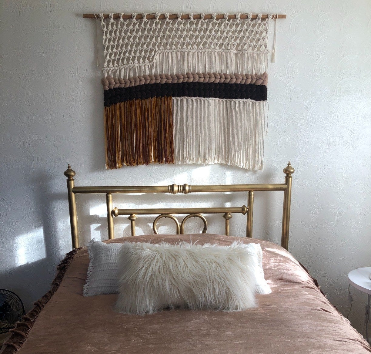 a person's macrame hanging over their bed