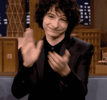 Finn Wolfhard smiling and clapping