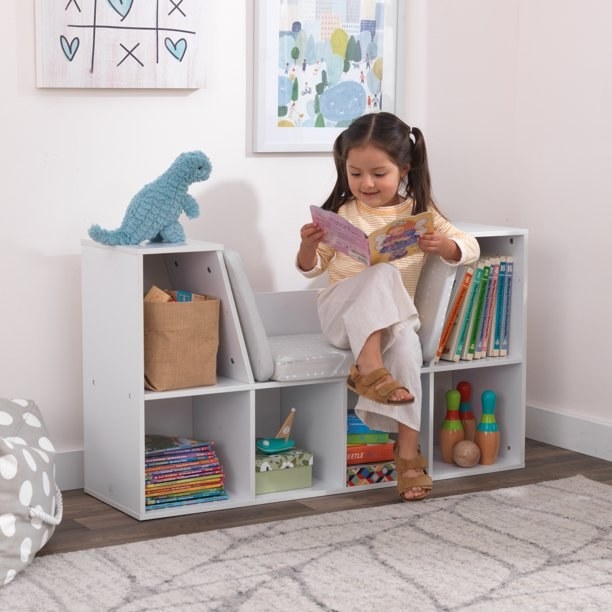 A bookcase with a seat in the middle