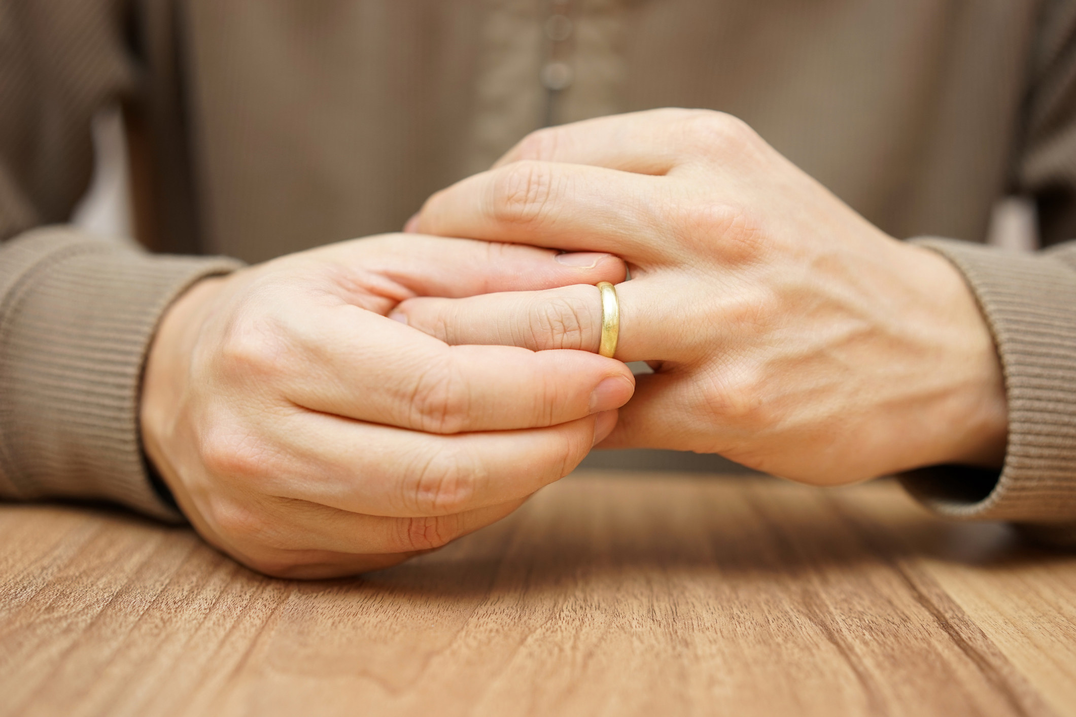 Hands removing a wedding ring