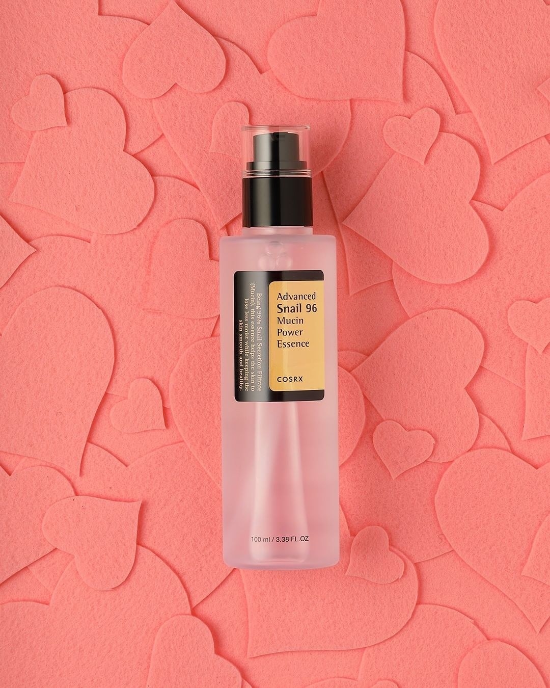 A bottle of essence on a background of felt hearts