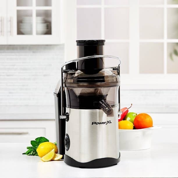 The self cleaning juice in a silver chrome color with black accents on a counter