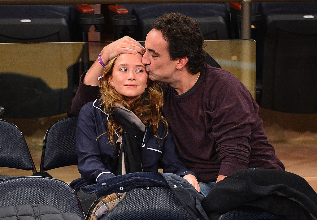 Olivier grabbing MK's head to give her a kiss on the side