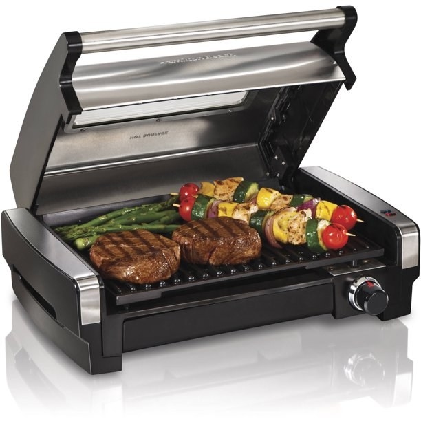 The grill with two steaks and vegetables on it