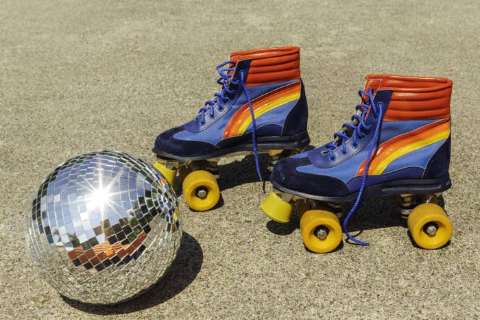 Retro rollerskates and disco ball. 1970s roller skates with rainbow stripe