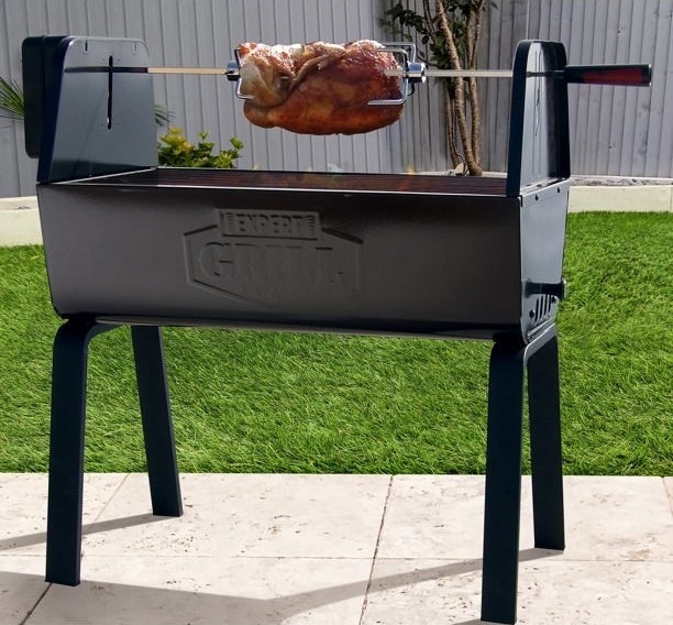 A portable rotisserie grill with a chicken on it