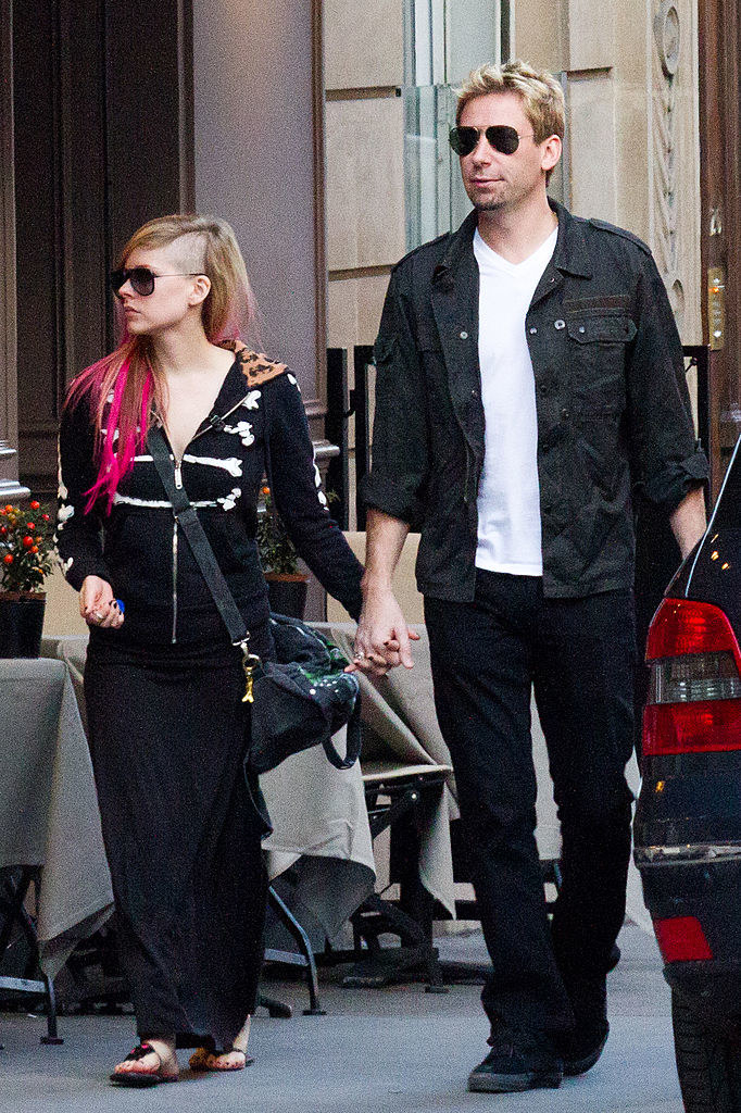 the two holding hands as they walk down the street