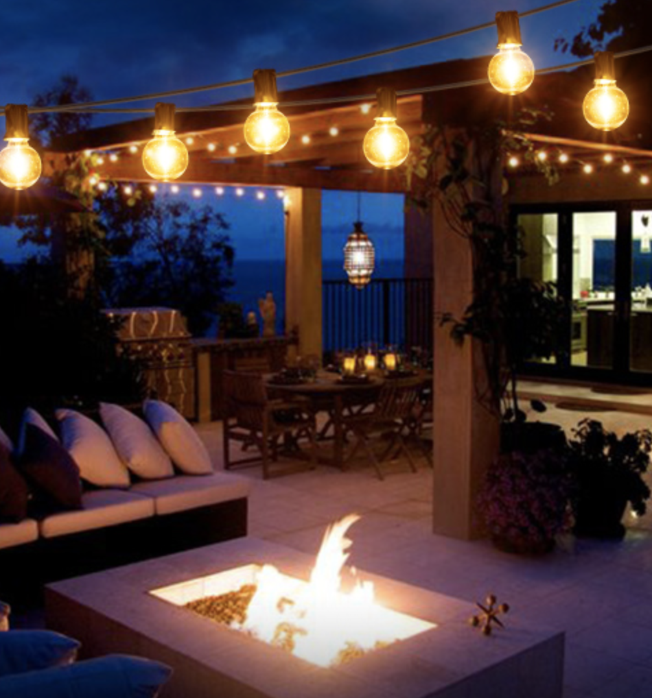 The globe lights hung over an outdoor patio with a fireplace
