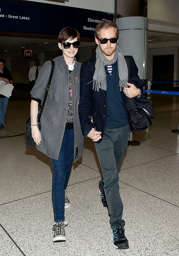 the two holding hands as they leave the airport