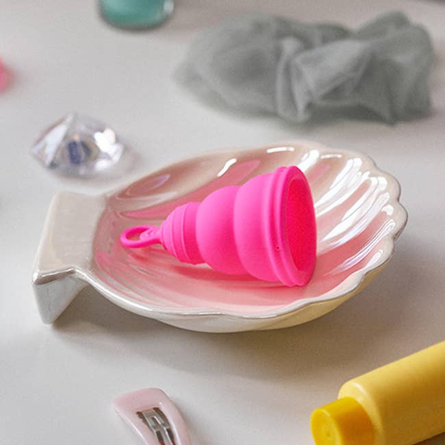 the lily cup one menstrual cup in a shell-shaped catch-all tray