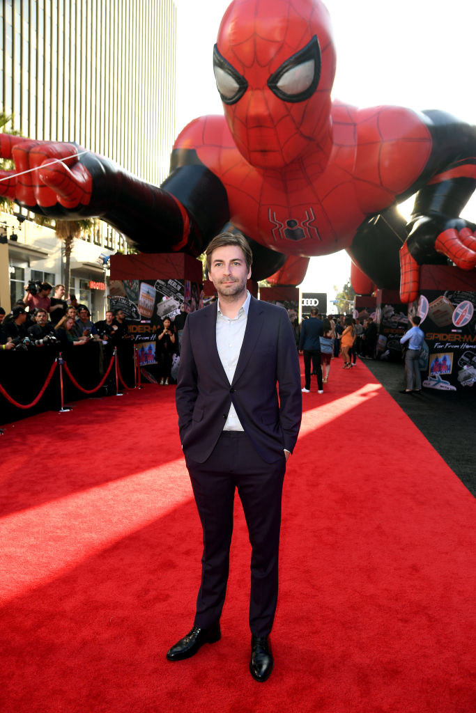 Jon Watts on the red carpet with a huge blow up of Spider-Man behind him