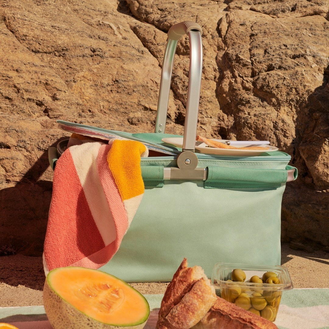The picnic basket on a beach in front of a picnic spread
