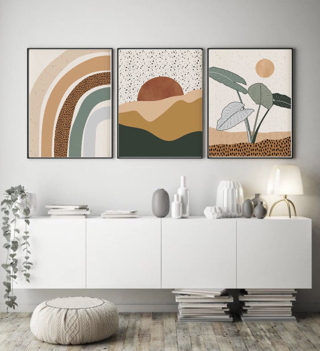 set of three digital abstract prints with a rainbow, plant, and sun framed above a white cabinet