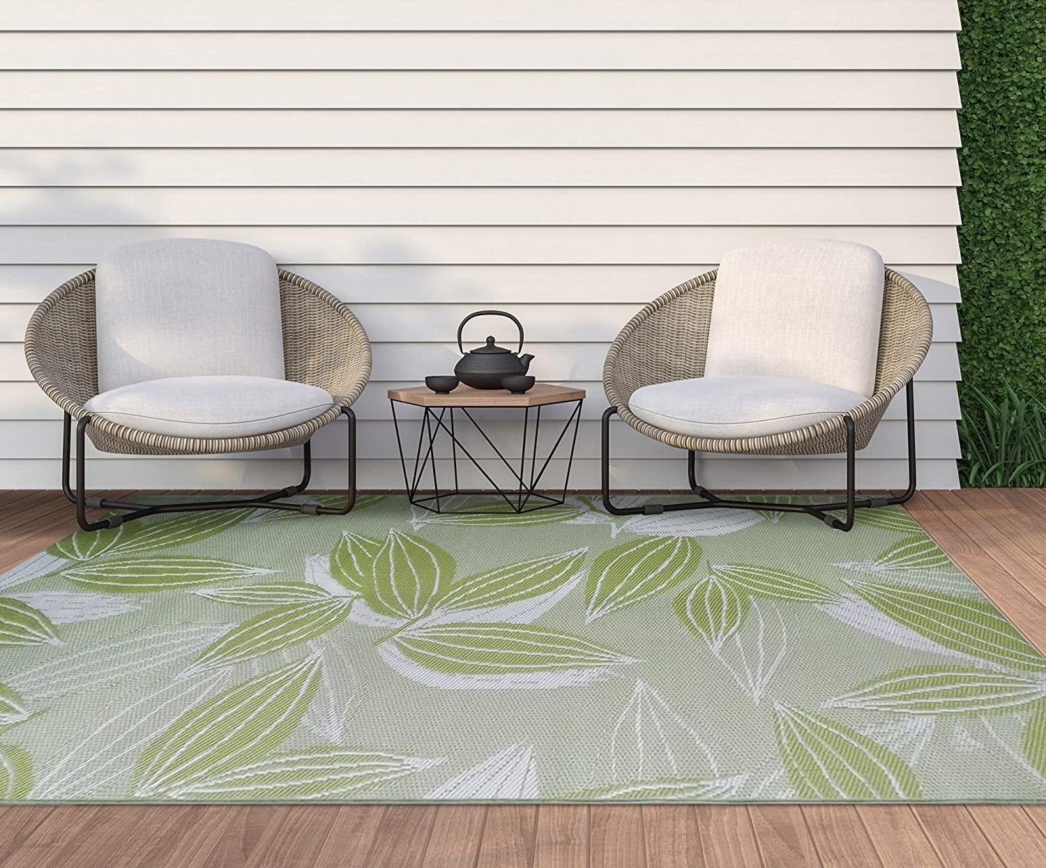 a patterned outdoor rug on a deck with two lounge chairs