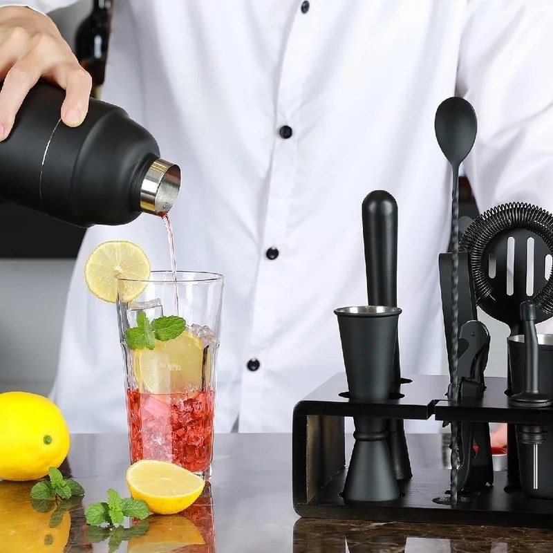 A model making a red drink with lemons with black bar tools