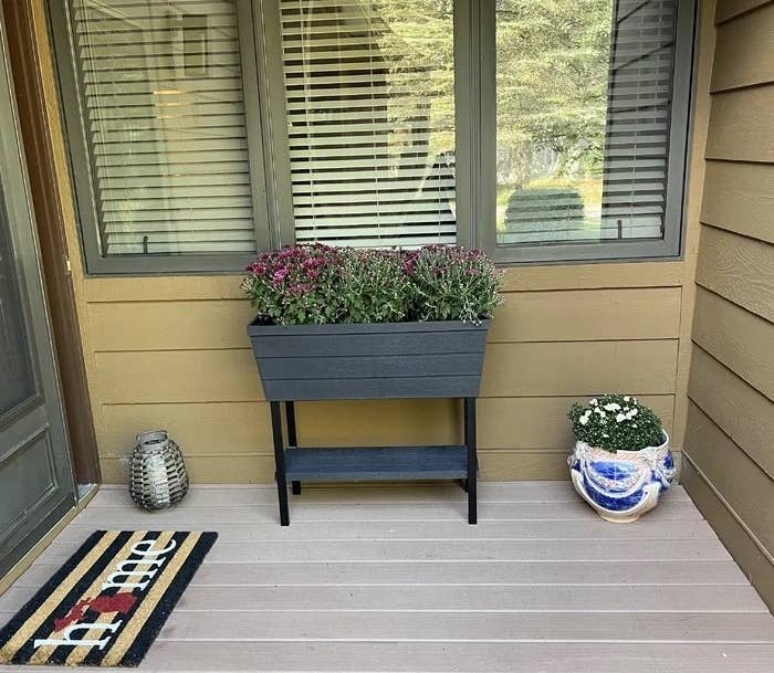 A planter standing outside a reviewer&#x27;s front door with flowers