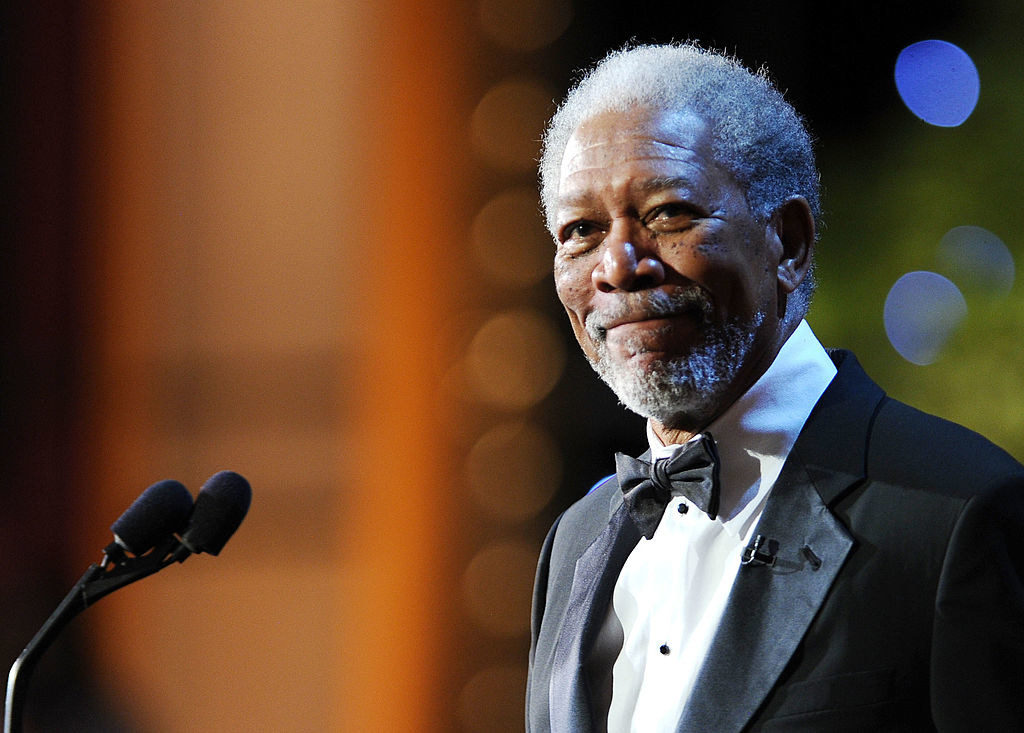 Morgan Freeman smiling and standing at a podium
