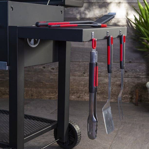 An image of a ten-piece stainless steel grill set that include a spatula, fork, tongs, basting brush, grill cleaning brush, and four grilling skewers