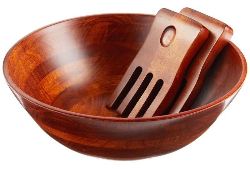 A brown salad bowl with utensils