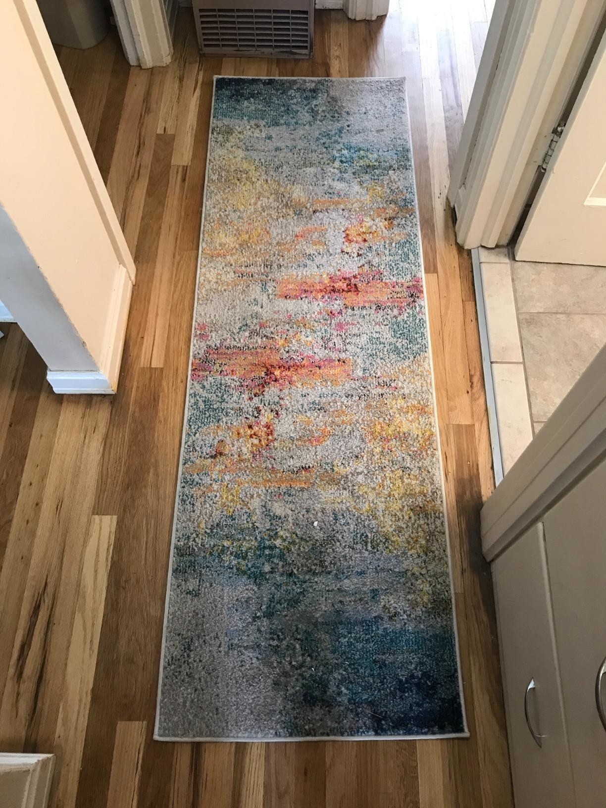 a reviewer photo of the rug in a hallway