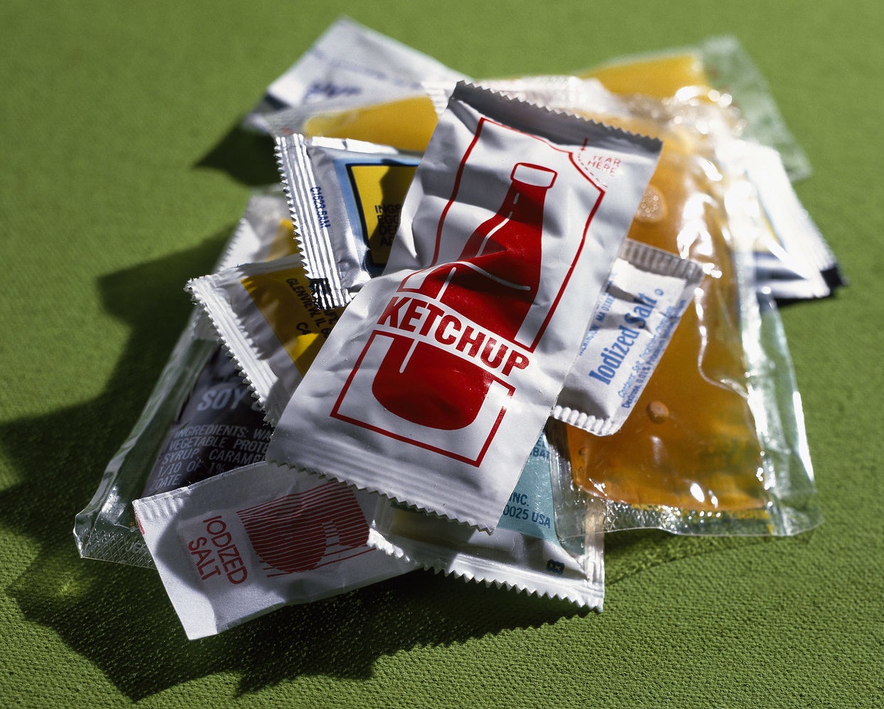 A stack of ketchup, salt, and other condiment packets