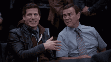 a gif of two characters from brooklyn nine-nine doing spirit fingers to each other