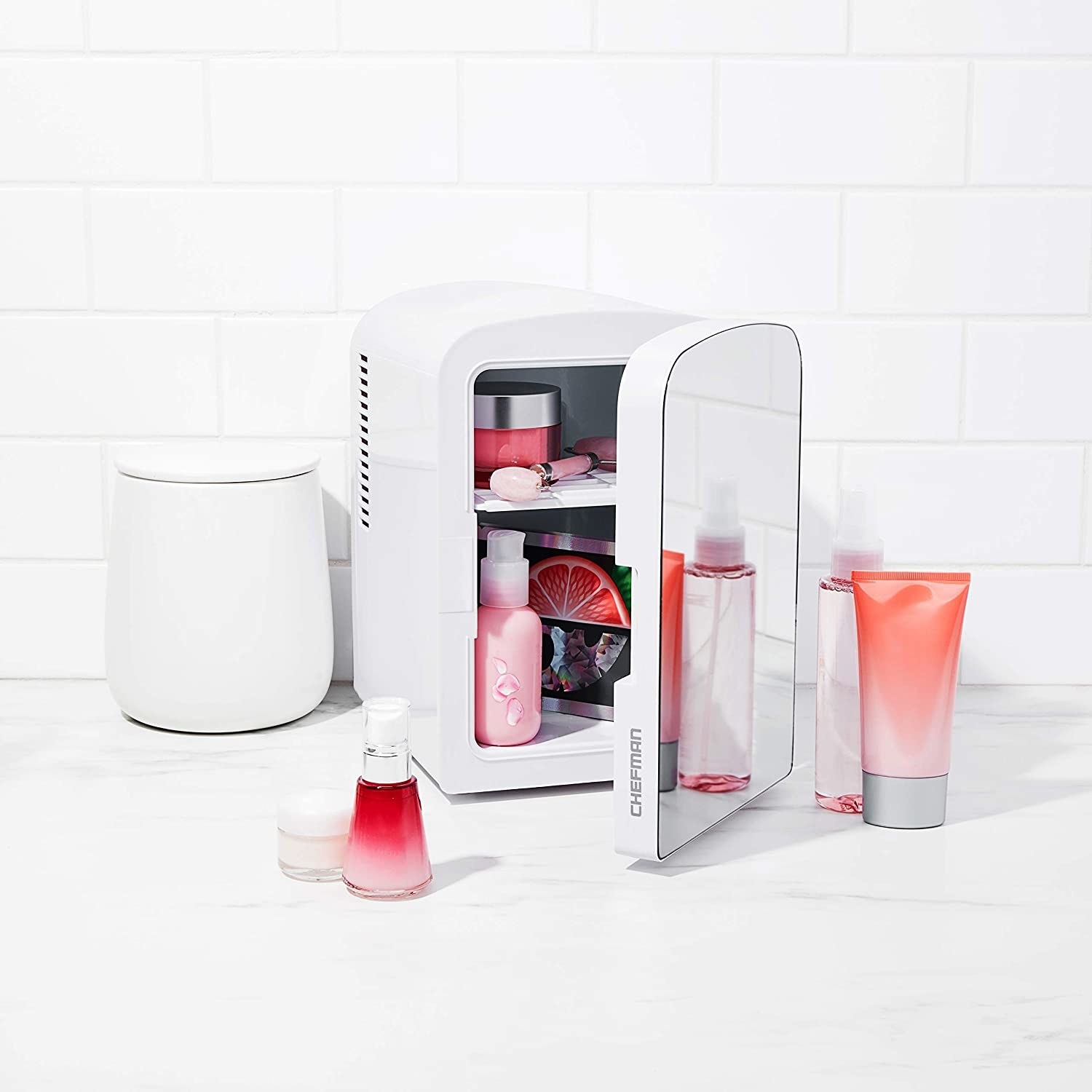 a mirrored mini fridge with skincare products inside