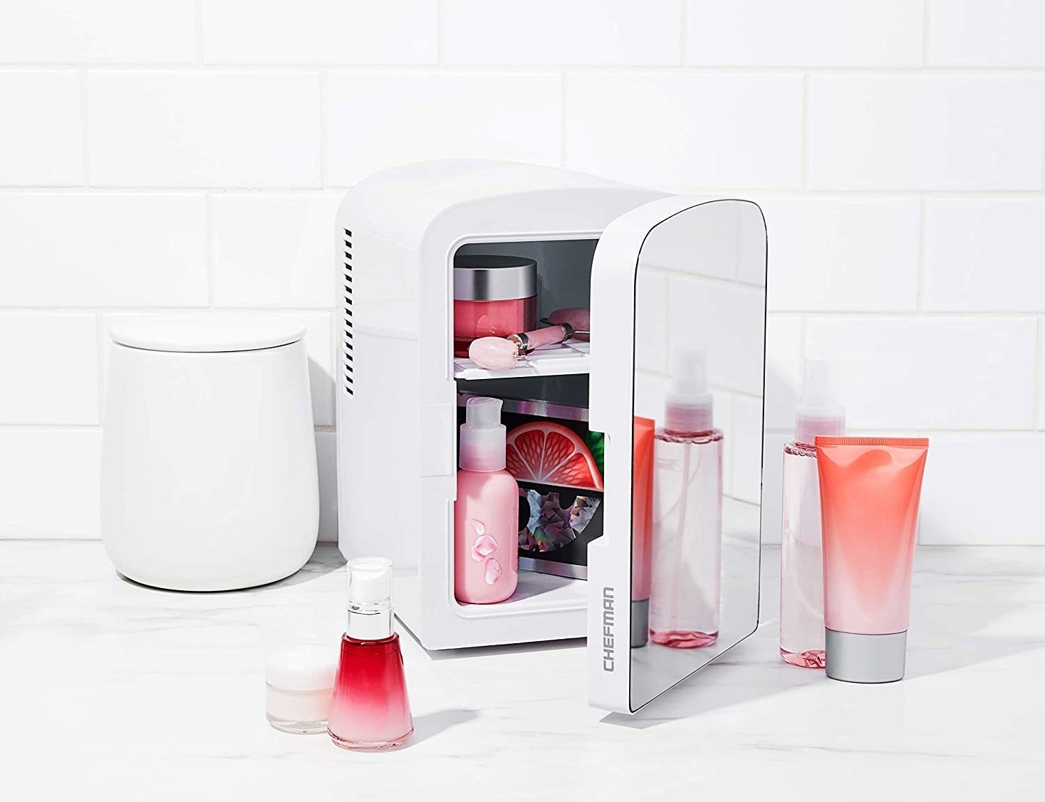 a mirrored mini fridge with skincare products inside