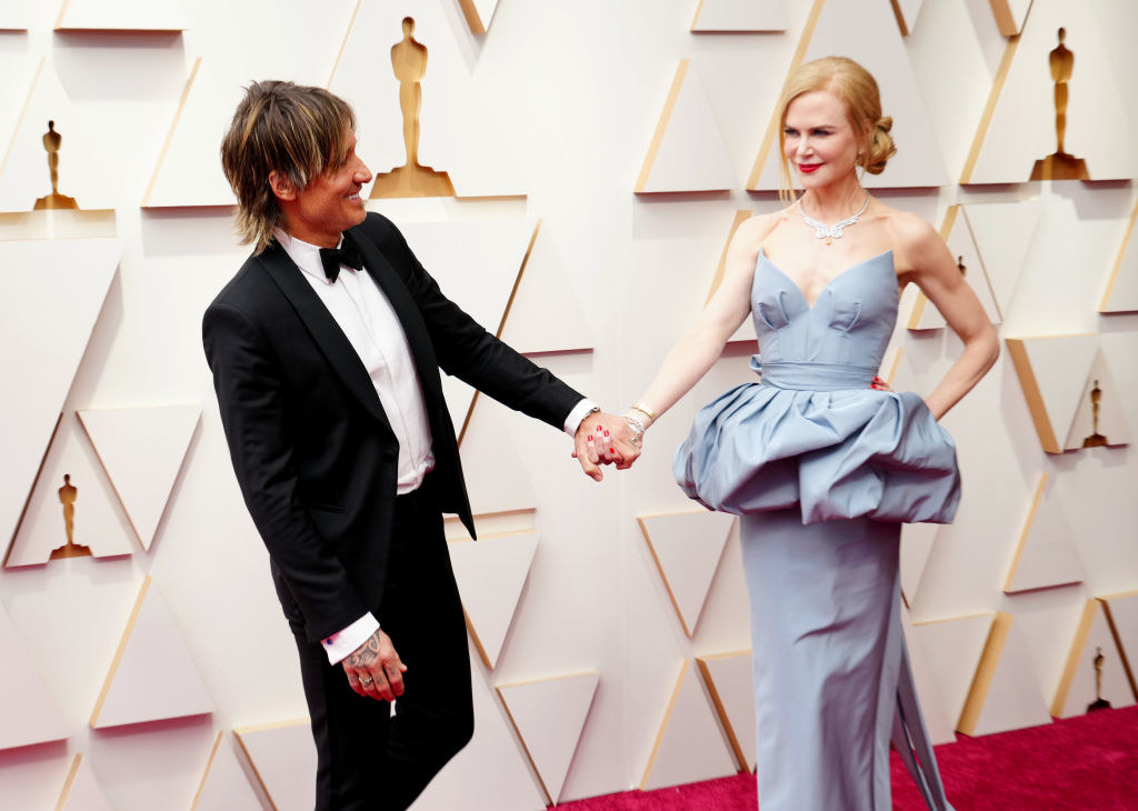 Nicole Kidman and Keith Urban hold hands and smile at each other at the Oscars