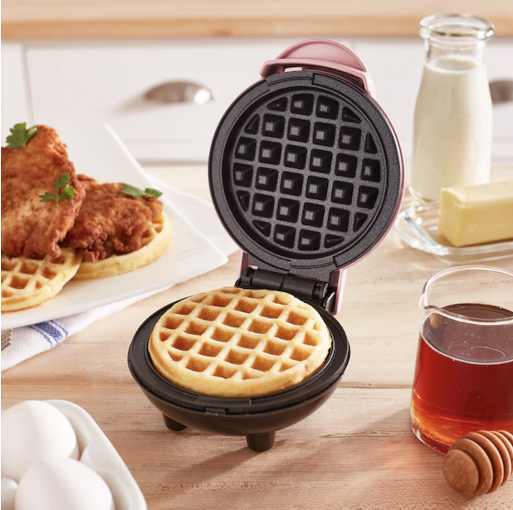 The waffle maker open revealing a cooked waffle inside