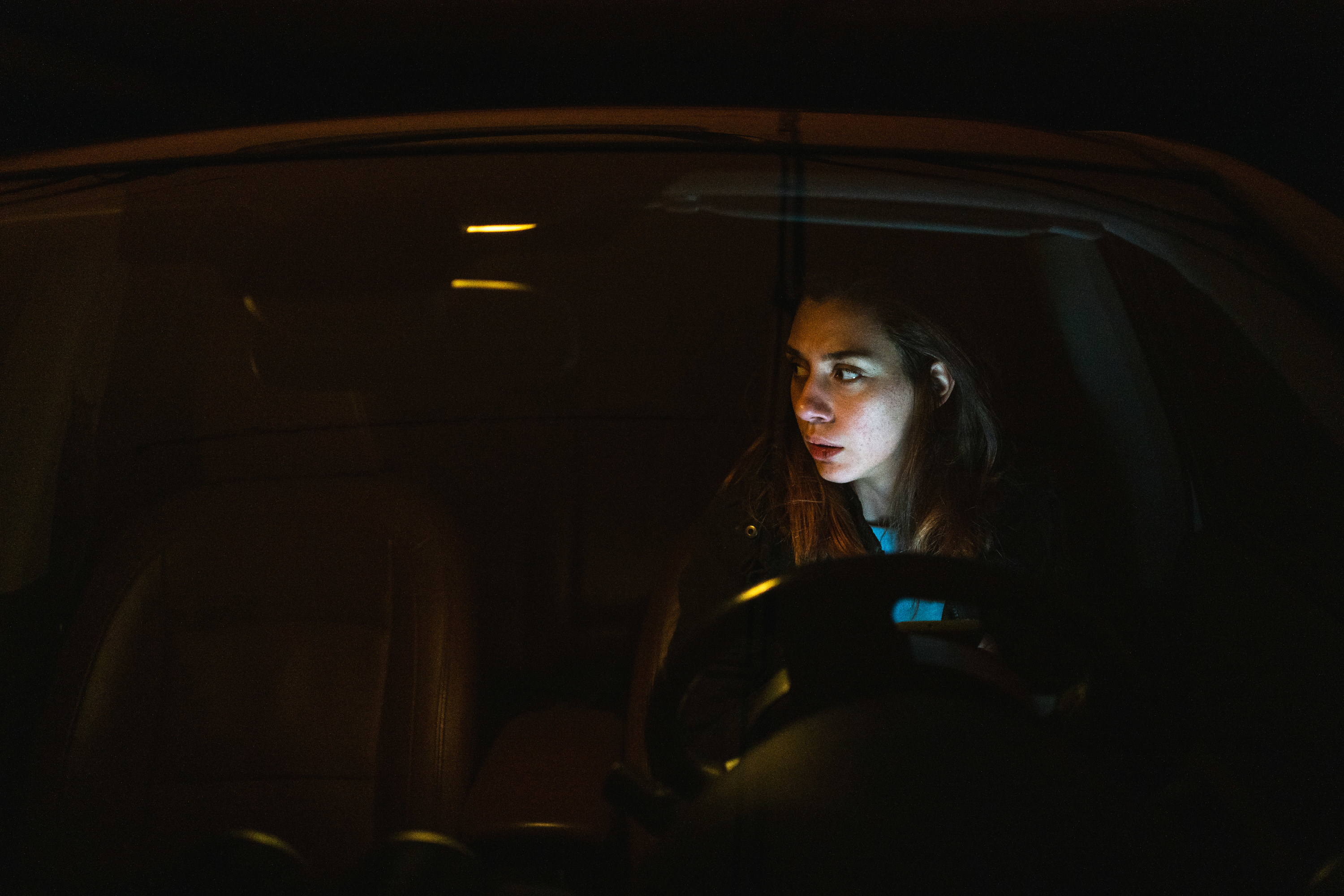 A woman in her car at night