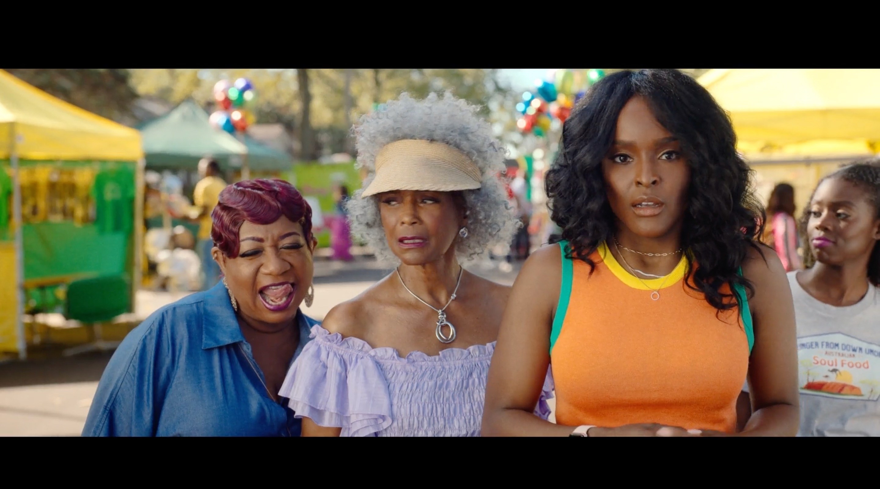 women at a block party stand together as one of them looks shocked