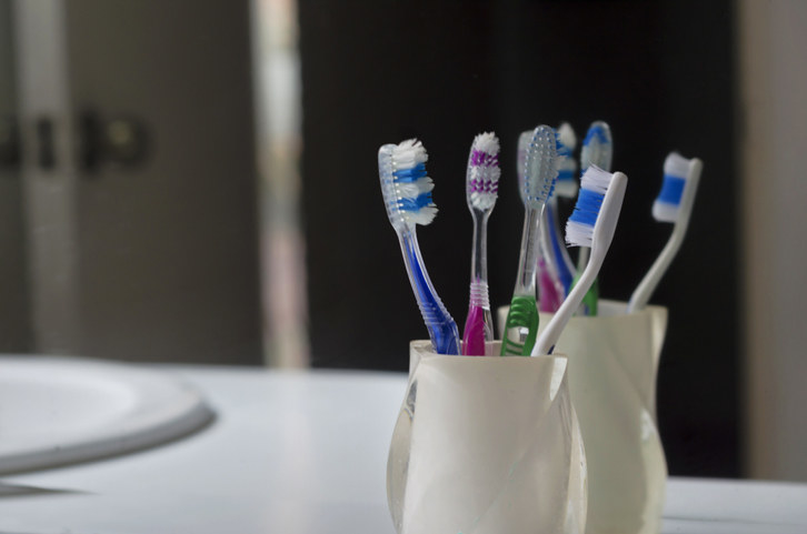 close up of toothbrushes in a cup