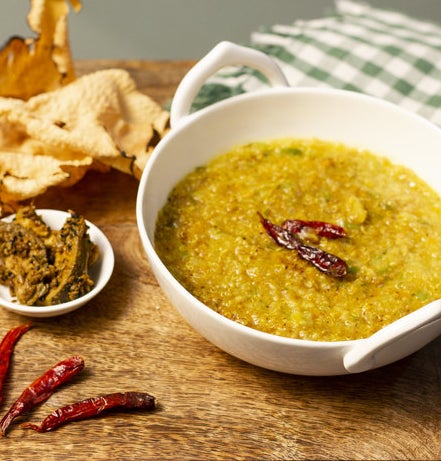 a bowl of lentils and rice soup dish with a pepper in the middle