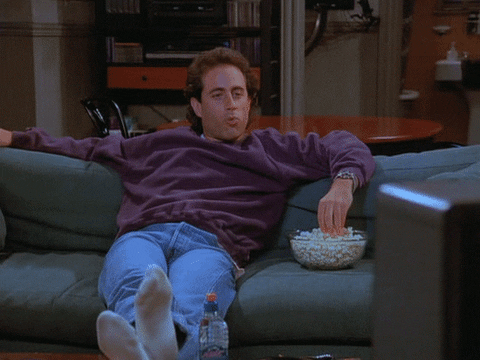 Jerry Seinfeld eating popcorn and watching TV
